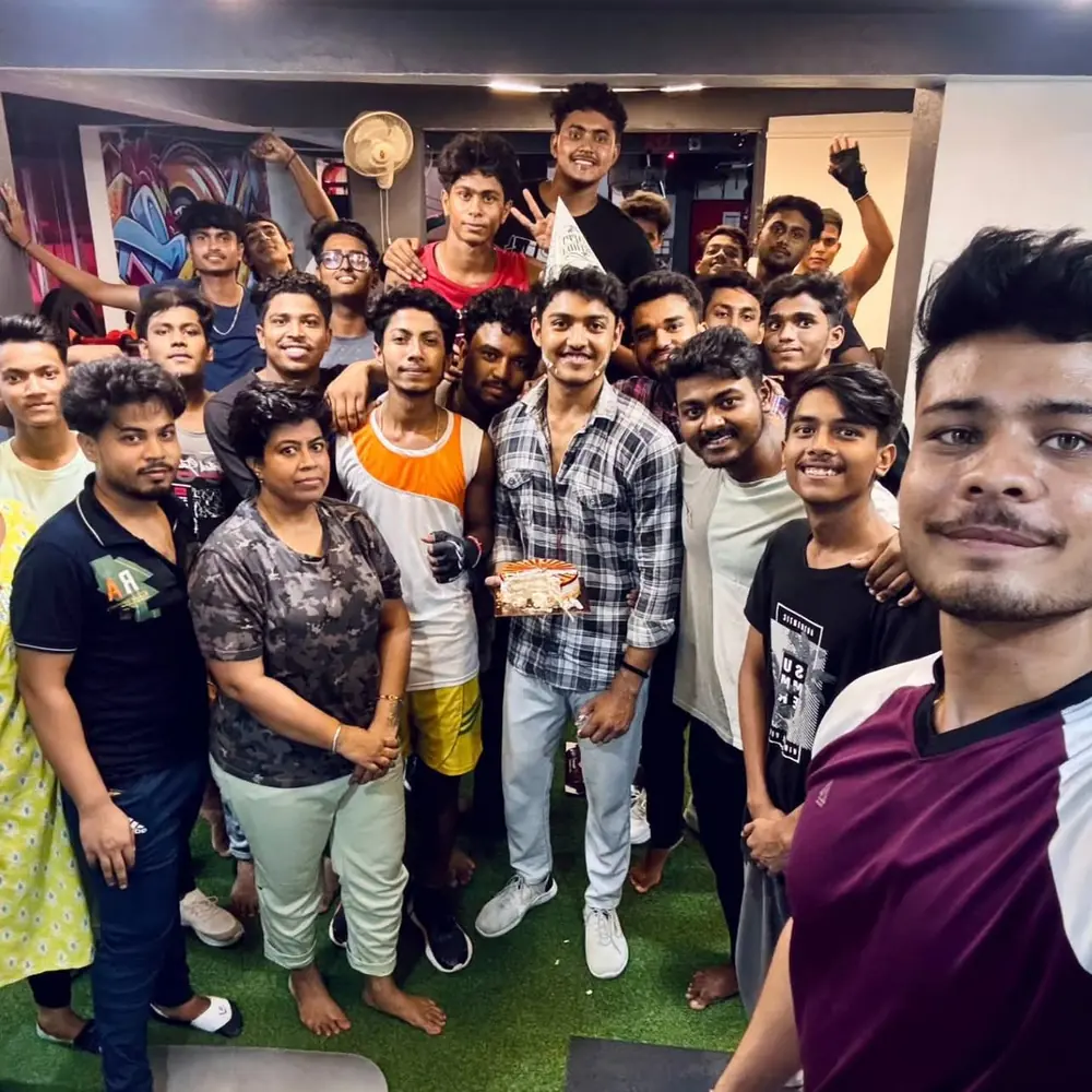Close group selfie of smiling M.S Fitness members celebrating with a cake